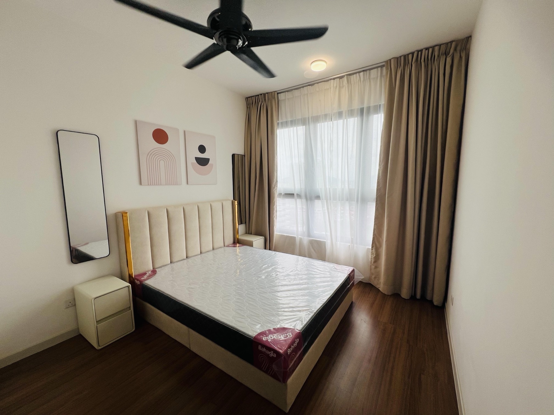 Master bedroom with channel-tufted cream bed frame, lean mirror and beige drapes